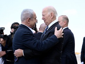 Israel Prime Minister Benjamin Netanyahu (L) greets US President Joe Biden upon his arrival at Tel Aviv's Ben Gurion airport on October 18, 2023, amid the ongoing battles between Israel and the Palestinian group Hamas. (Photo by BRENDAN SMIALOWSKI/AFP via Getty Images)