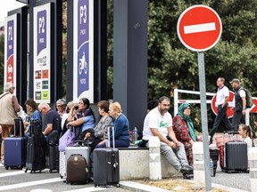 Travellers wait outside the Toulouse-Blagnac Airport in Blagnac, southwestern France, on October 18, 2023, after the airport has been evacuated. (Photo by CHARLY TRIBALLEAU/AFP via Getty Images)