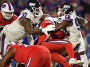 Buffalo Bills running back Damien Harris, centre, is hit by New York Giants linebacker Bobby Okereke (58) and defensive lineman Dexter Lawrence II (97) during the first half of an NFL football game in Orchard Park, N.Y., on Sunday, Oct. 15, 2023. Harris's neck was injured on the play and he left the field in an ambulance.