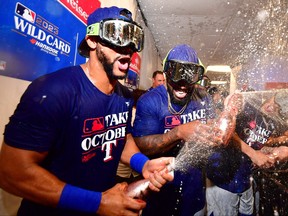 Leody Taveras and Adolis Garcia of the Texas Rangers celebrate in the clubhouse after defeating the Tampa Bay Rays 7-1 in Game Two of the Wild Card Series at Tropicana Field on Oct. 4, 2023 in St. Petersburg, Fla.