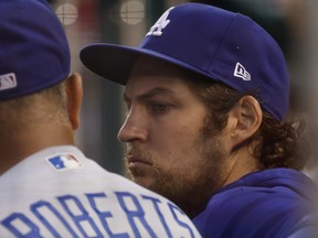 Los Angeles Dodgers starting pitcher Trevor Bauer (right) talks with Dodgers manager Dave Roberts in the dugout in 2021.
