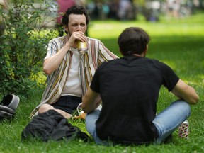 A man drinks a beer in Trinity Bellwoods Park.