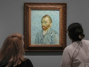 People look at Vincent Van Gogh's oil on canvas painting, Self-portrait, 1889, at the Musee d'Orsay in Paris.