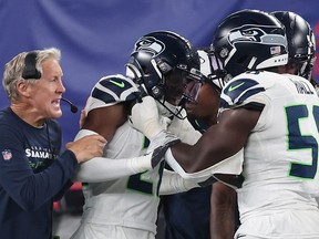 Devon Witherspoon of the Seattle Seahawks celebrates his interception return for a touchdown with Head coach Pete Carroll and teammates during the third quarter against the New York Giants at MetLife Stadium on Oct. 2, 2023 in East Rutherford, N.J.
