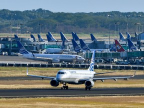 A Copa airlines plane taxis on a runway as others sit on the tarmac at Tocumen International Airport on March 22, 2020.