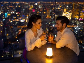 Couple pictured at a rooftop bar at night