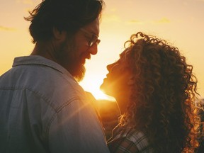 Man and woman adult relationship in outdoor love leisure activity enjoying golden sunset and looking each other with love and tenderness. People attraction lifestyle. Emotions and feeling on vacation
