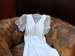Wedding dress lies on a vintage brown leather chair