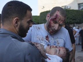 Palestinians wounded in Israeli air strikes on the Gaza Strip are brought to al-Aqsa hospital in Deir el-Balah City, Gaza Strip, Saturday, Oct. 14, 2023.