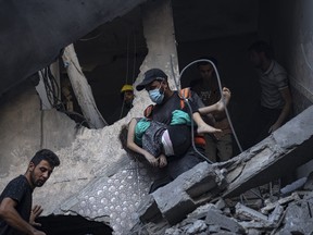 Palestinians evacuate wounded from a building destroyed in Israeli bombardment in Khan Younis, Gaza Strip, Thursday, Oct. 19, 2023.