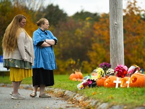 People pay their respects at a makeshift memorial