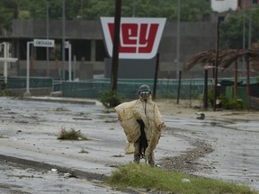 A Mexican soldier guards near an avenue flooded