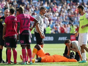 Clermont-Ferrand's French goalkeeper Mory Diaw lies on the ground after being injured by a firecracker
