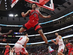Scottie Barnes of the Toronto Raptors leaps over Zach LaVine (8) of the Chicago Bulls during the first half at the United Cente.