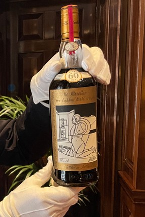 A member of staff shows a bottle of the Macallan Valerio Adami 60 Year Old 42.8 abv 1926 during a photocall at the auction house Sotheby's in London, on Oct. 19, 2023.