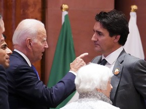 Prime Minister Justin Trudeau, right, and U.S. President Joe Biden speak as they arrive to take part in a working session at the G20 Summit in New Delhi, India on Saturday, Sept. 9, 2023.