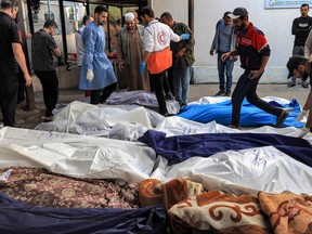 A picture shows the covered bodies of Palestinians killed in an Israeli airstrike at a hospital in Rafah, southern Gaza Strip, on October 19, 2023.