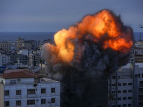 Fire and smoke rise following an Israeli airstrike, in Gaza City, Sunday, Oct. 8, 2023.
