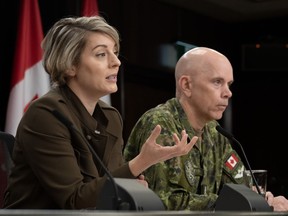 Chief of the Defence Staff Wayne Eyre listens as Foreign Affairs Minister Melanie Joly responds to a reporter's question during a news conference in Ottawa, Wednesday, Oct. 11, 2023.