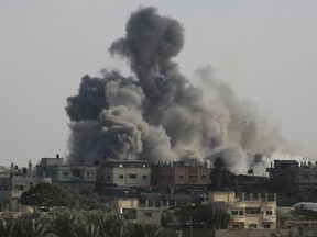Smoke rises from an explosion caused by Israeli airstrikes on the border between Egypt and Rafah, Gaza Strip, Tuesday, Oct. 10, 2023.