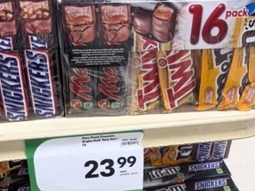 Grocery store shelf showing 16-pack of chocolate bars for $23.99.