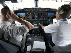 Pilots conduct a pre-flight check in the cockpit