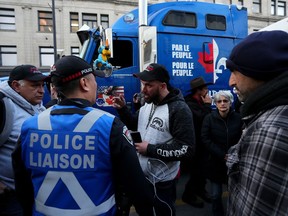 Crown prosecutors are set to continue their chief-in-examination of an officer who served as a liaison between police and convoy organizers. A protesting truck driver, centre, discusses with police liaison how to leave the area during a demonstration, part of a convoy-style protest participants are calling "Rolling Thunder", in Ottawa, Friday, April 29, 2022.