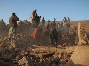 Afghan residents clear debris from a damaged house after earthquake in Sarbuland village of Zendeh Jan district of Herat province on Oct. 7,2023.