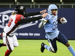 Argonauts running back Javon Leake (right) returns the ball while Redblacks long snapper Tanner Doll (left) attempts to make the tackle, during first half CFL action in Toronto, Saturday, Oct. 14, 2023.