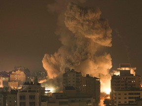 Fire and smoke rise above buildings in Gaza City during an Israeli air strike on Oct. 8, 2023.