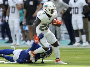 New York Giants safety Isaiah Simmons (19) grabs Miami Dolphins running back De'Von Achane (28) before Achane fumbled the ball during the first half of an NFL football game, Sunday, Oct. 8, 2023, in Miami Gardens, Fla.