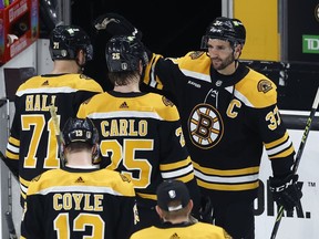 Boston Bruins' Patrice Bergeron (top right) greets teammates