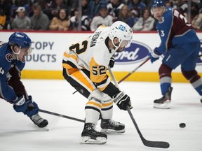 Pittsburgh Penguins defenceman Mark Friedman, right, fields the puck after driving past Colorado Avalanche defenseman Bowen Byram in the second period of an NHL hockey game Wednesday, March 22, 2023, in Denver. The Vancouver Canucks have acquired Friedman and forward Ty Glover from the Penguins.