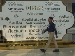 A man walks past a welcome sign