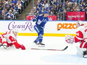 Maple Leafs' Matthew Knies shoots at Detroit Red Wings goaltender Alex Lyon as Detroit's Simon Edvinson defends during second-period pre-season action in Toronto, on Thursday, Oct. 5, 2023.