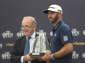 FILE - Dustin Johnson, right, receives The Mark H McCormack award for being the leading playing in the Official World Golf rankings for 2018, from OWGR Chairman Peter Dawson during a ceremony ahead of the British Open golf championships at Royal Portrush in Northern Ireland, Tuesday, July 16, 2019. Dawson says the OWGR has denied the application for LIV Golf to receive ranking points.