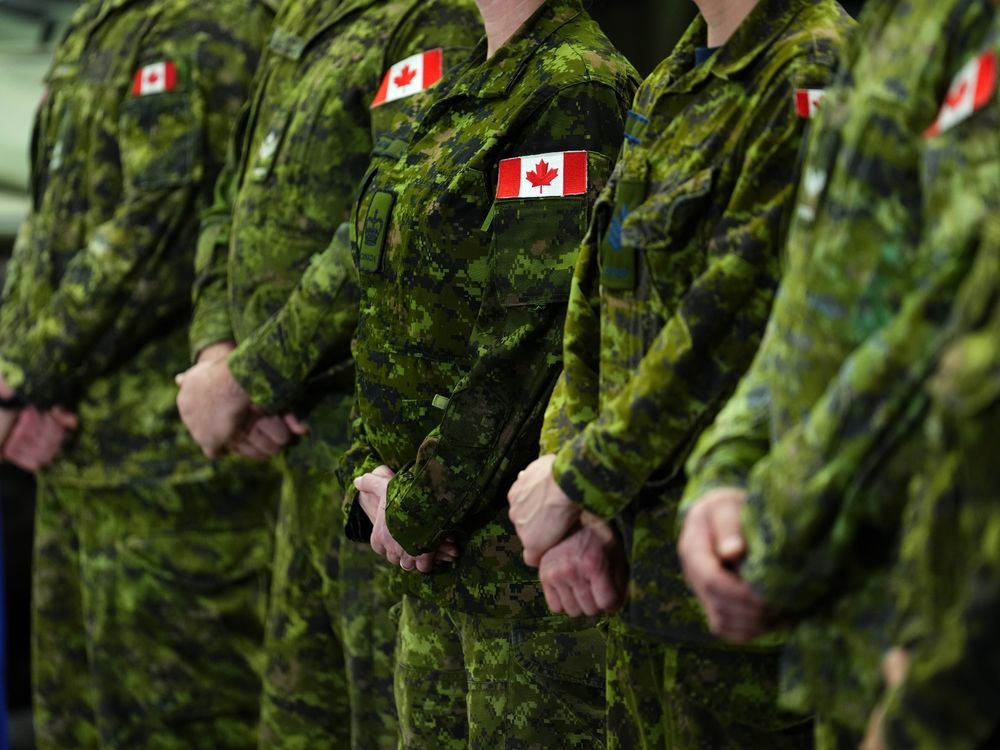 Canadian military members rappel from the roof of the Rogers