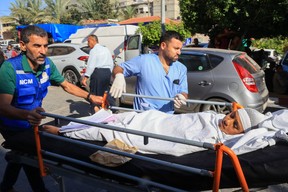 A Palestinian child injured during an Israeli air strike is wheeled into the Nasser hospital in Khan Yunis on the southern Gaza Strip on Oct. 17, 2023.