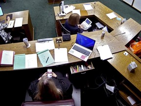 In this image from security camera video, Lincoln County District Judge Traci Soderstrom looks at her cellphone during a murder trial, at the Lincoln County District Court in Chandler, Okla., June 12, 2023.