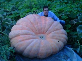 Travis Gienger poses with a giant pumpkin he grew in 2014.