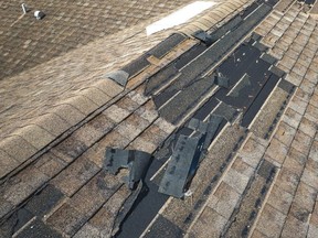 A roof on a house with missing and damaged shingles.