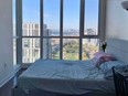 Bedroom with queen-size bed overlooking Toronto.