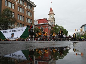 People look on as members of the Shorecrest Highlanders marching band perform during the 123rd Victoria Day parade in Victoria, B.C., on Monday, May 22, 2023.