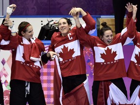 Canadian players including captain Caroline Ouellette celebrate after beating the United States 3-2 in overtime in the women's hockey final at the 2014 Sochi Winter Olympics.