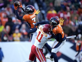 Denver Broncos safety Justin Simmons, left, intercepts a pass intended for Kansas City Chiefs wide receiver Marquez Valdes-Scantling.