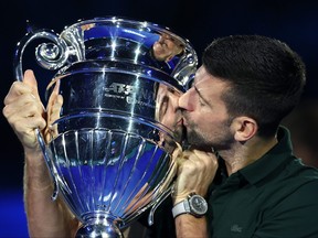 Novak Djokovic of Serbia kisses the ATP Year End World Number One Trophy.