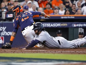 Eugenio Suarez of the Seattle Mariners slides home to score a run against the Houston Astros.