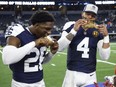 Dallas Cowboys cornerback DaRon Bland, left, and quarterback Dak Prescott celebrate by eating Thanksgiving turkey legs.