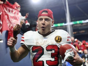 Christian McCaffrey of the San Francisco 49ers walks off the field eating a turkey leg after beating the Seattle Seahawks.