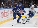 John Klingberg of the Toronto Maple Leafs returns to the lineup and carries the puck against Nils Hoglander of the Vancouver Canucks during the first period at Scotiabank Arena on November 11, 2023 in Toronto, Ontario, Canada.